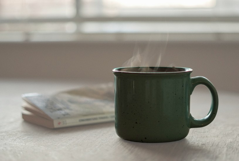 Mug of coffee on a table with a book. Photo by https://unsplash.com/@thomascpark