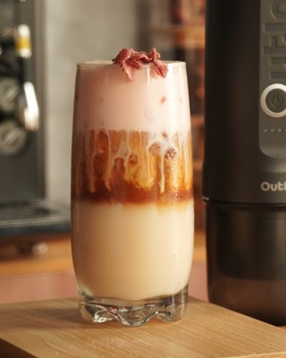Specialty crafted coffee in a glass next to OutIn Nano